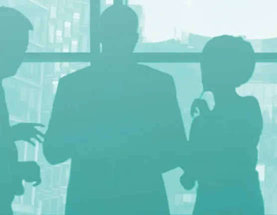 Silhouettes d’une équipe devant une baie vitrée