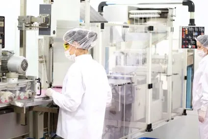 Opératrices en tenue de salle propre devant des équipements de production